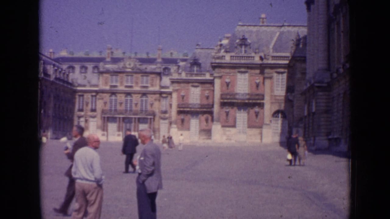 1962 Paris plaza scene with scattered tourists, a foreground pair, and ornate multi-storey architecture.