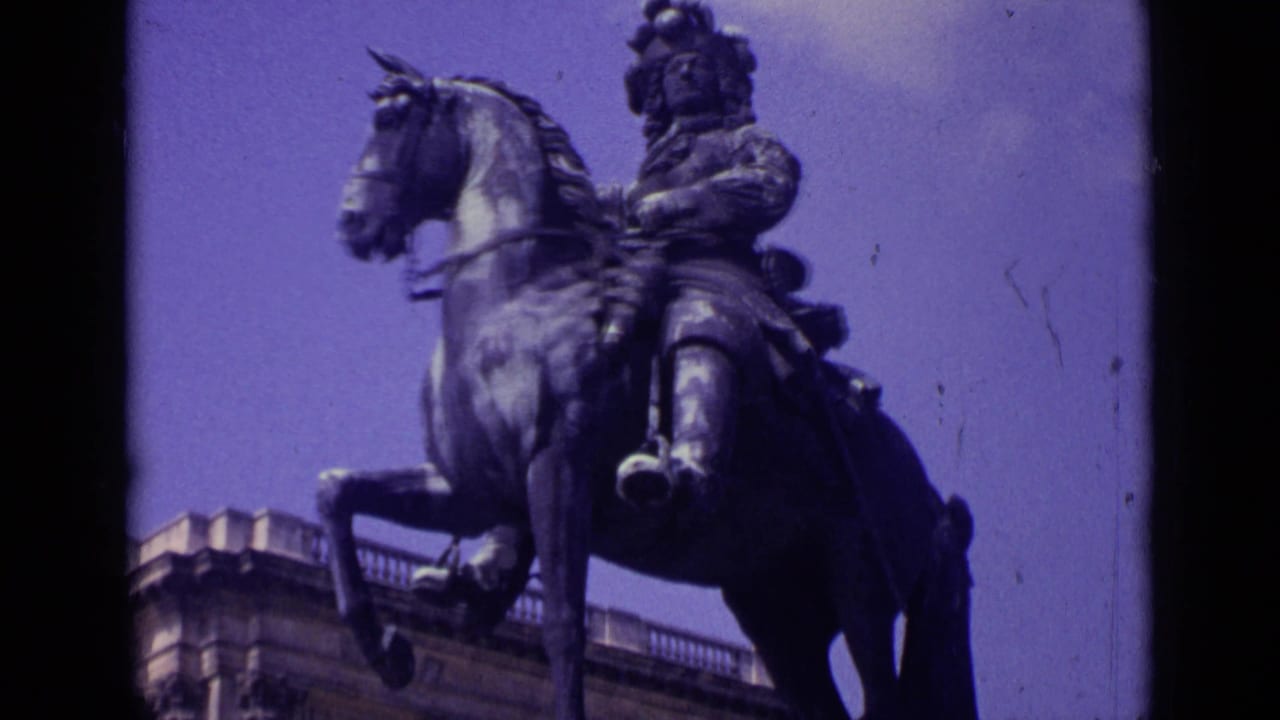 Equestrian statue seen from below against sky and nearby stone architecture.