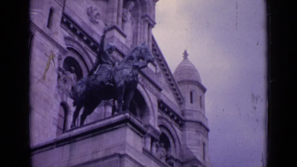 Paris landmark exterior detail with an equestrian statue, arched stone facade, carved ornament, and a domed tower visible above.