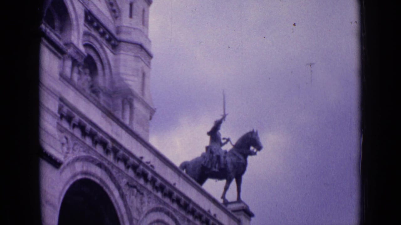 1962 Paris landmark view with an equestrian statue on a raised base, arched stone architecture, and cloudy sky.