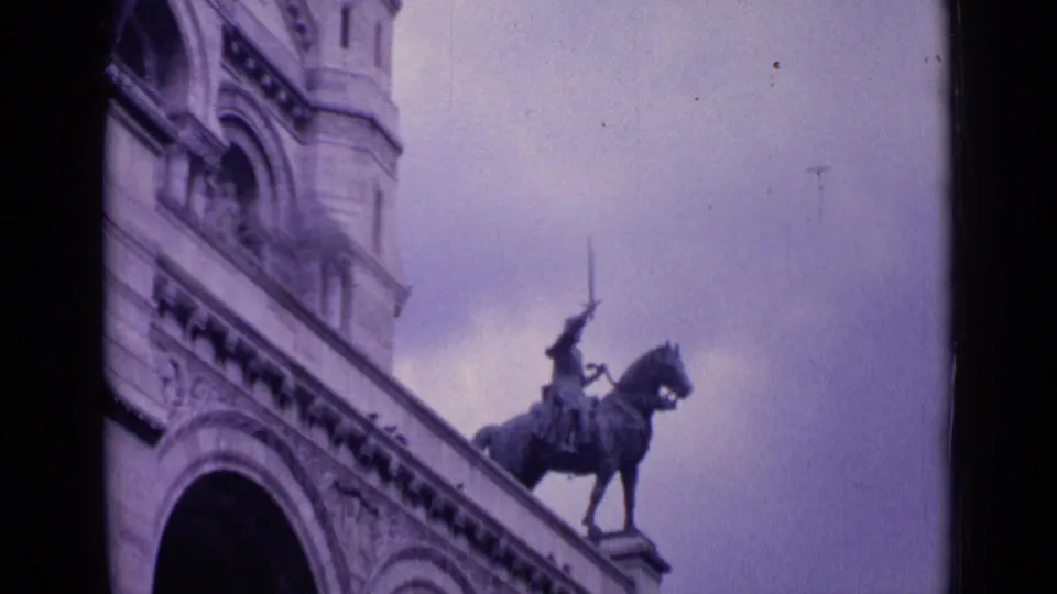 1962 Paris landmark view with an equestrian statue on a raised base, arched stone architecture, and cloudy sky.