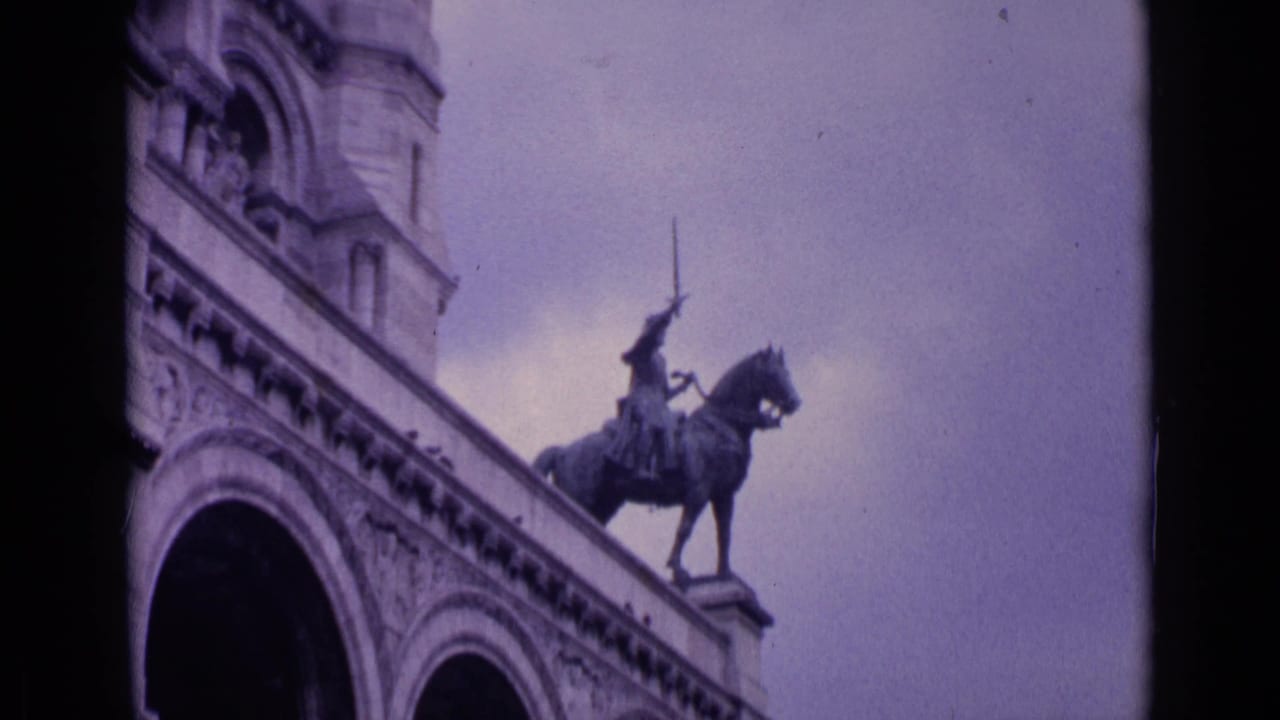 Ornate Paris building facade with an equestrian statue above arched masonry.