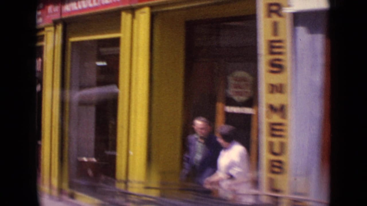 Yellow Paris storefront with pedestrians near a vertical sign and shop entrance.