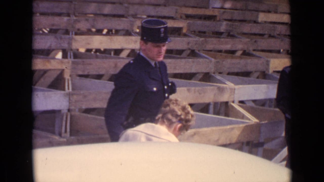 At the end of the 1962 Paris clip, the policeman looks across the scene while the woman lowers her head near a car edge.