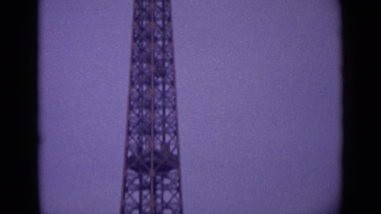 Mid-pan 1962 Paris frame showing the Eiffel Tower's iron framework, cropped tightly with visible film gate borders.