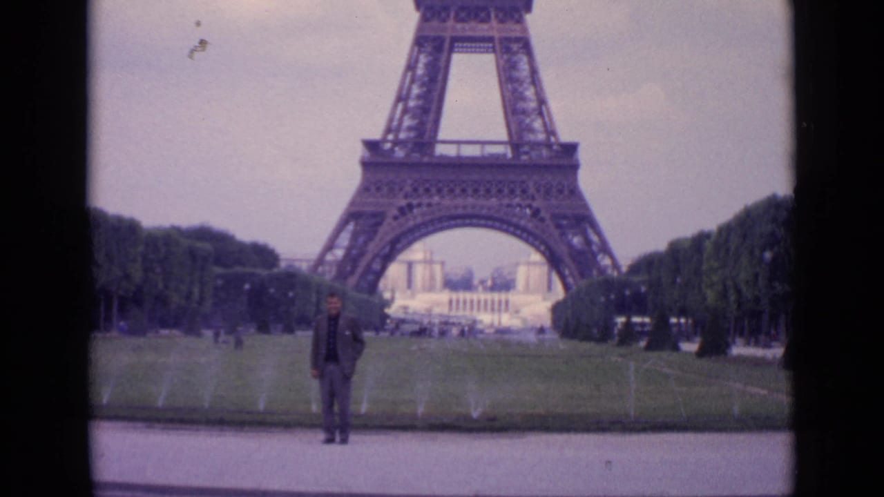 1962 Paris 8mm frame showing the Eiffel Tower over a suited man on a path, with fountains spraying across the lawn.
