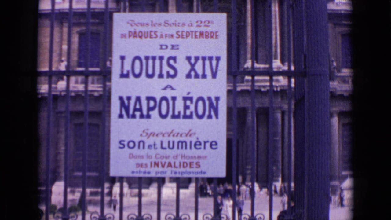 1962 Paris home-movie frame showing a Louis XIV to Napoléon poster behind dark iron gate bars at Invalides.