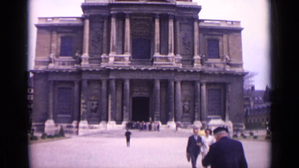 1962 Paris home-movie view of adults crossing a plaza in front of a large historic building with columns.