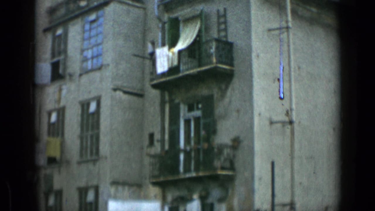 Weathered apartment building with balconies, windows, and laundry hanging outside.