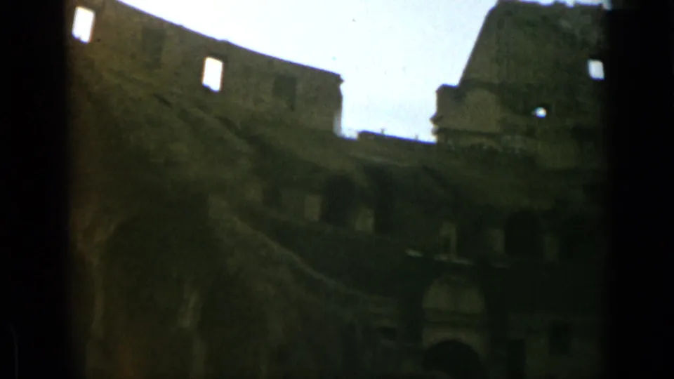 Rome Colosseum interior view on 8mm film, with dark arches below and broken stonework above.