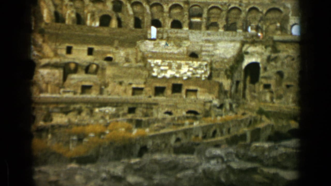 Colosseum interior with arched stone walls and exposed lower ruins.