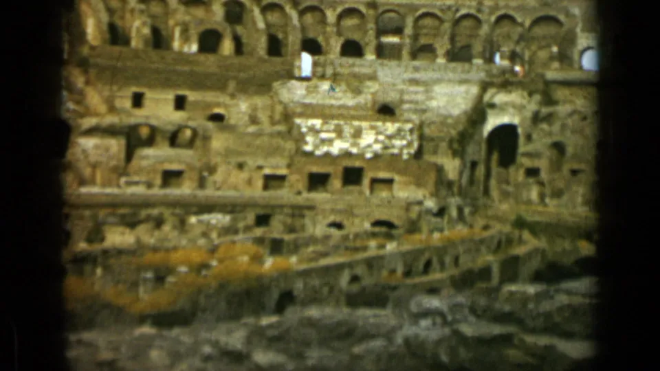 1962 Rome home-movie frame showing the Colosseum interior, worn arches, masonry walls, and arena substructures.