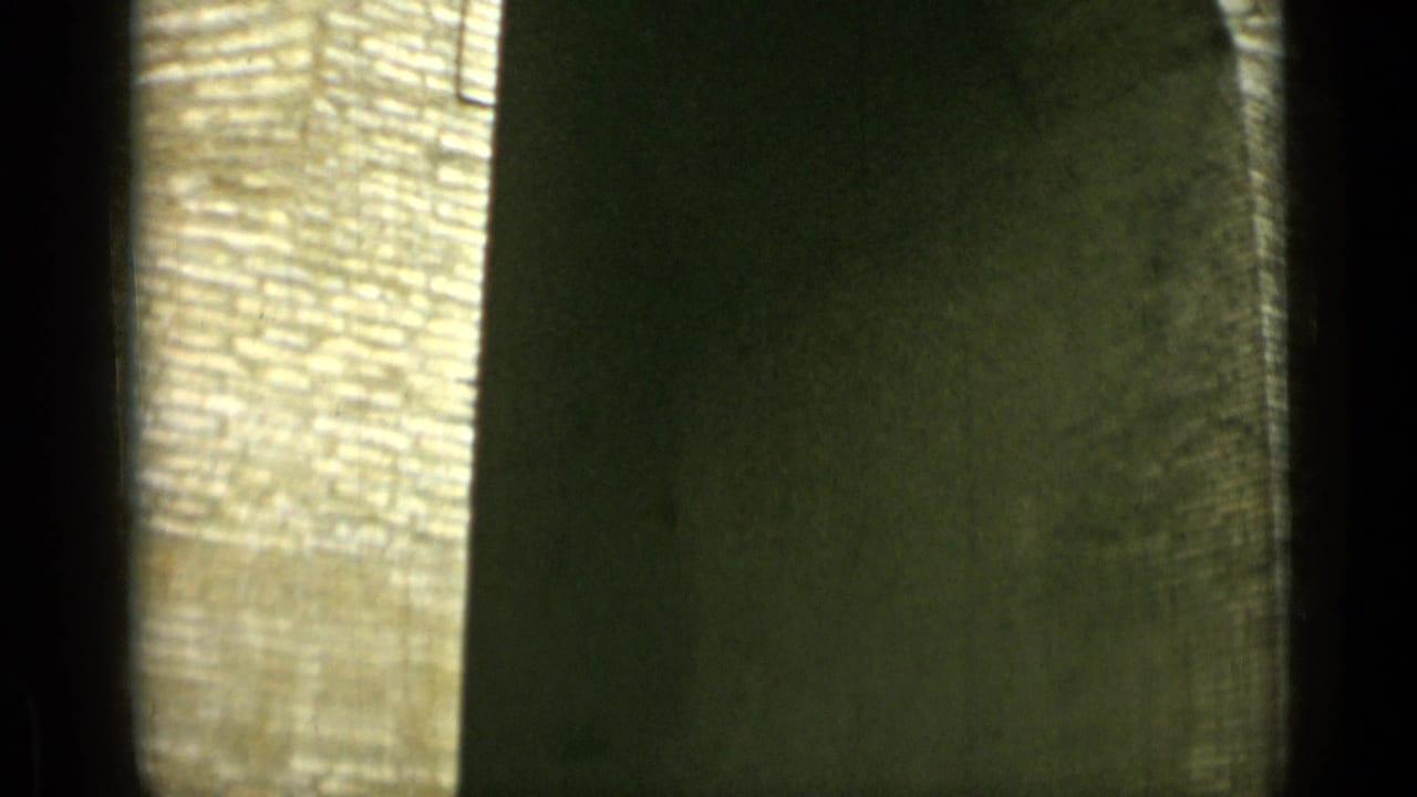 Soft 8mm view of a rounded stone arch with dark shadow inside.