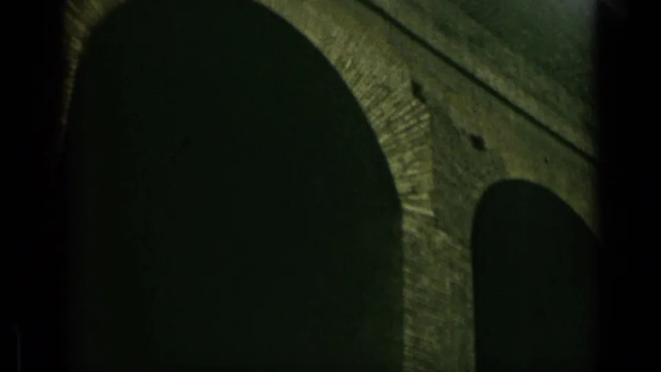 1962 Rome 8mm frame showing adjacent rounded arch shadows beneath weathered masonry, with soft focus and film grain.