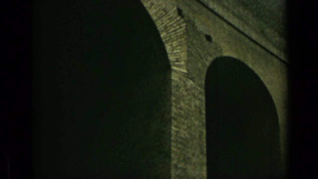 Close view of large stone arches with deep shadowed openings.