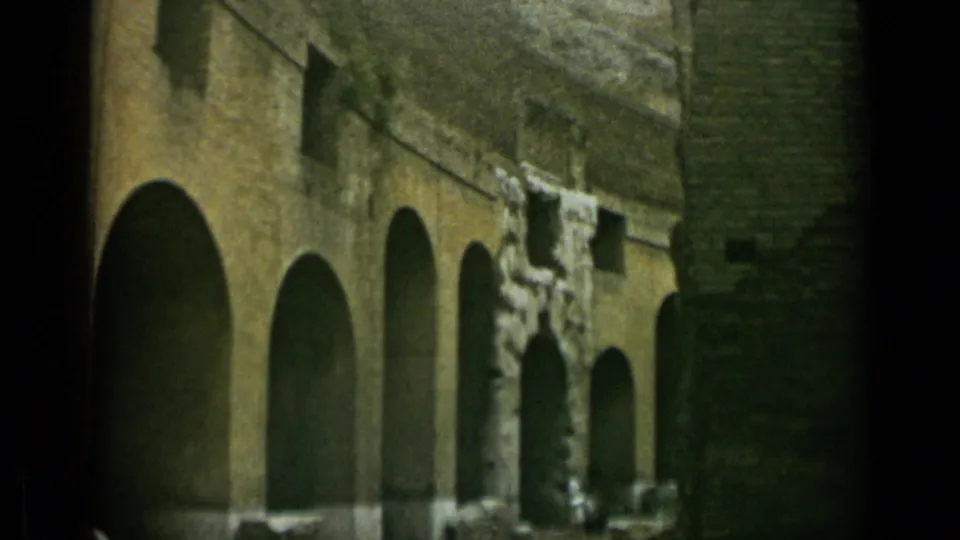 1962 Rome frame showing a closer section of Colosseum arches, broken masonry edges, and shadowed interior openings.