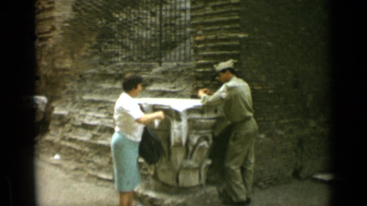 Woman extends her hand toward a uniformed man beside a stone pedestal.