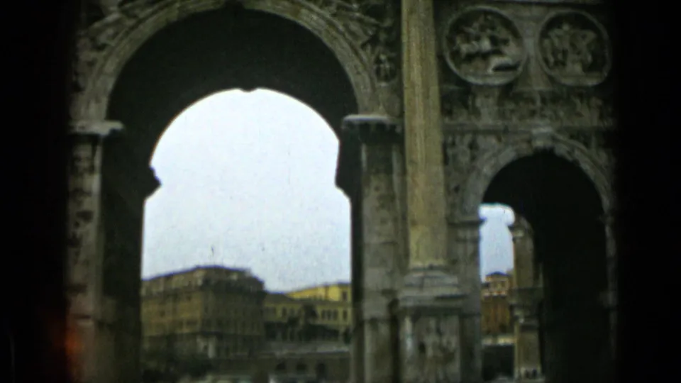 Rome architectural cutaway on 8mm film, showing carved stone arches and distant buildings framed through a large opening.