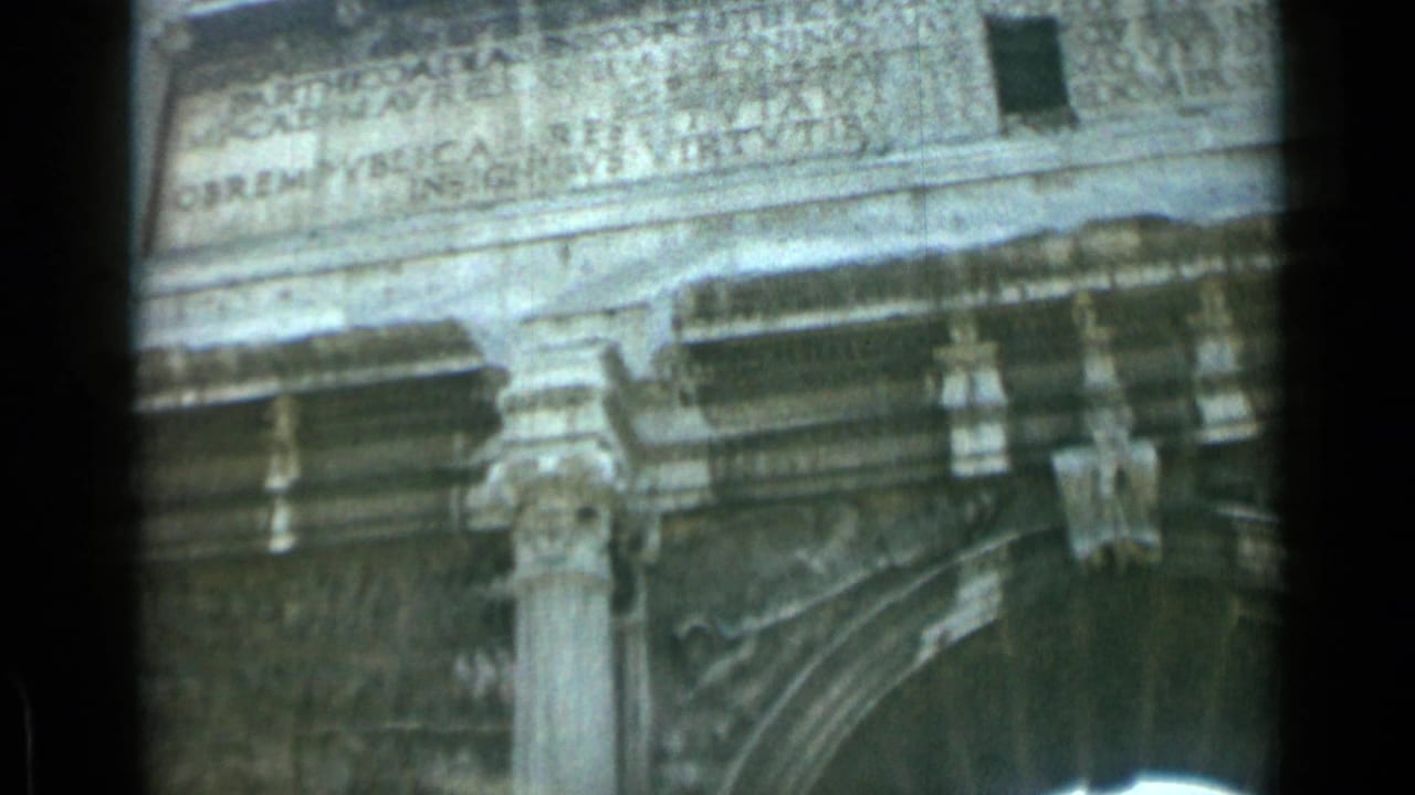Close view of carved Roman stonework with Latin inscription and columns.
