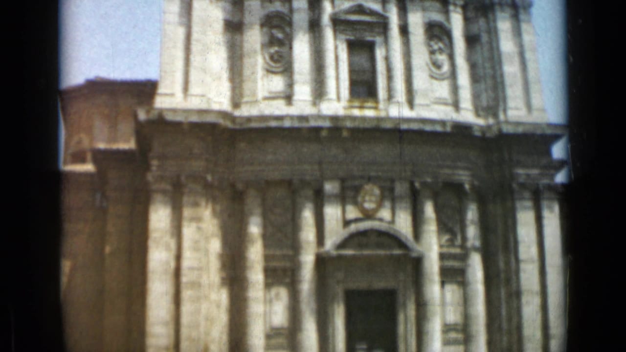 Ornate church facade framed closer, with columns, niches, and upper entrance area.