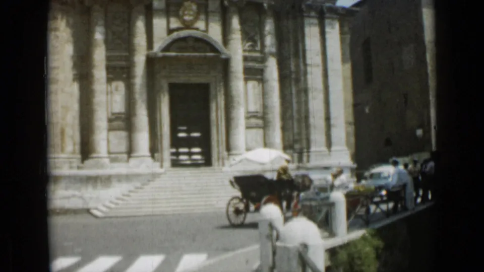 1962 Rome street view at the church entrance, with a horse-drawn carriage, pedestrians, cars, and crosswalk markings in front.