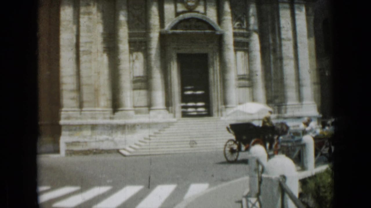 Stone building entrance with steps, zebra crossing, horse carriage, cars, and pedestrians.