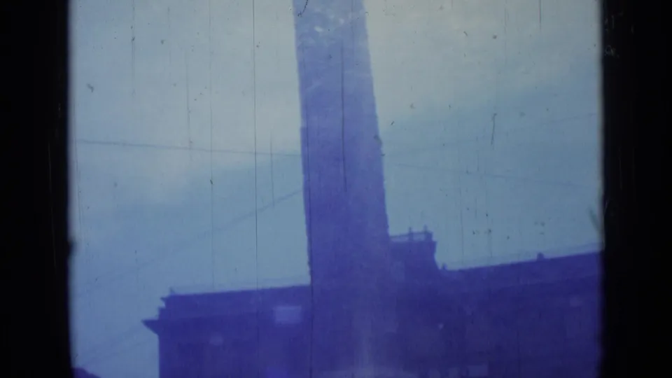 Blue-shifted 1962 Rome frame with the upper section of a tall monument and a shadowed roofline below.