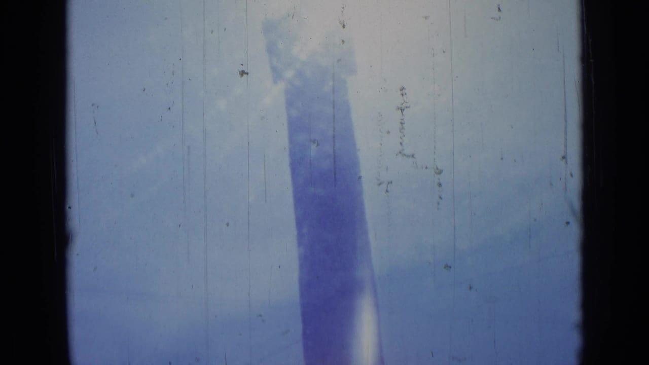 Obelisk column near the center-right, softened by glare and film scratches.