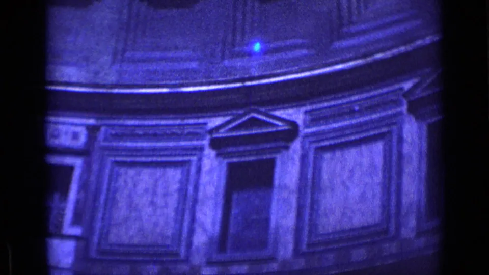 1962 Rome 8mm frame showing blue-tinted classical interior details with framed panels, cornices, and a dark opening.
