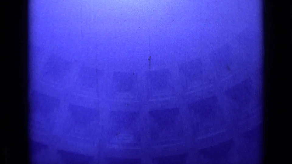 Soft blue-purple frame from the 1962 Rome clip, showing an indistinct architectural surface with curved and linear forms.