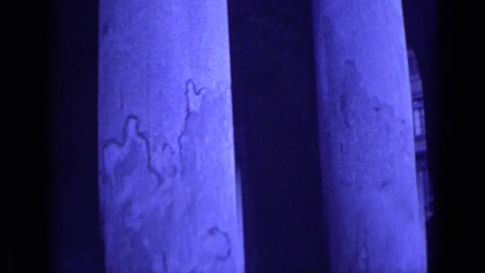 1962 Rome close-up of monumental stone columns, their weathered surfaces filling most of the handheld 8mm frame.