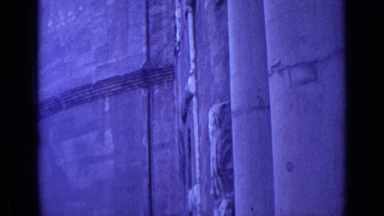 Facade detail divided by a dark vertical strip, with columns and worn surface texture.