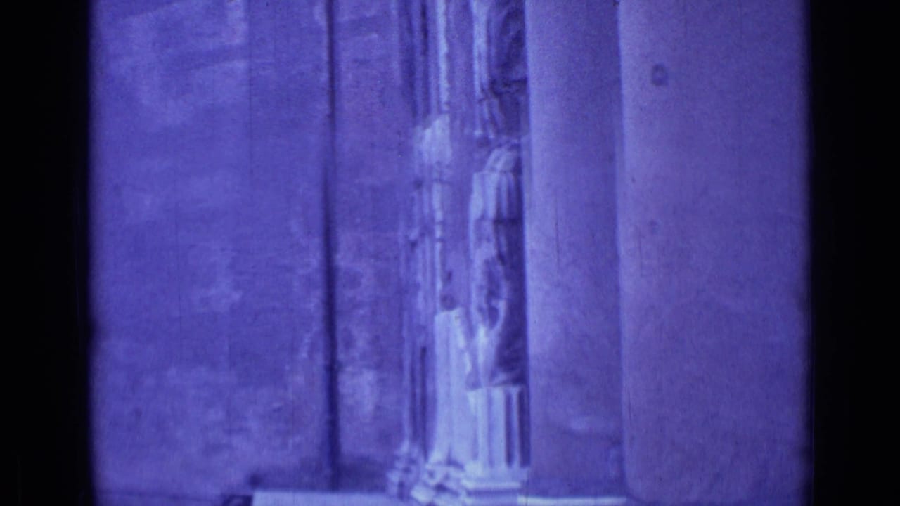 1962 Rome 8mm frame showing purple-tinted stone pilasters and carved religious entrance details, partly obscured by dark film edge shadows.