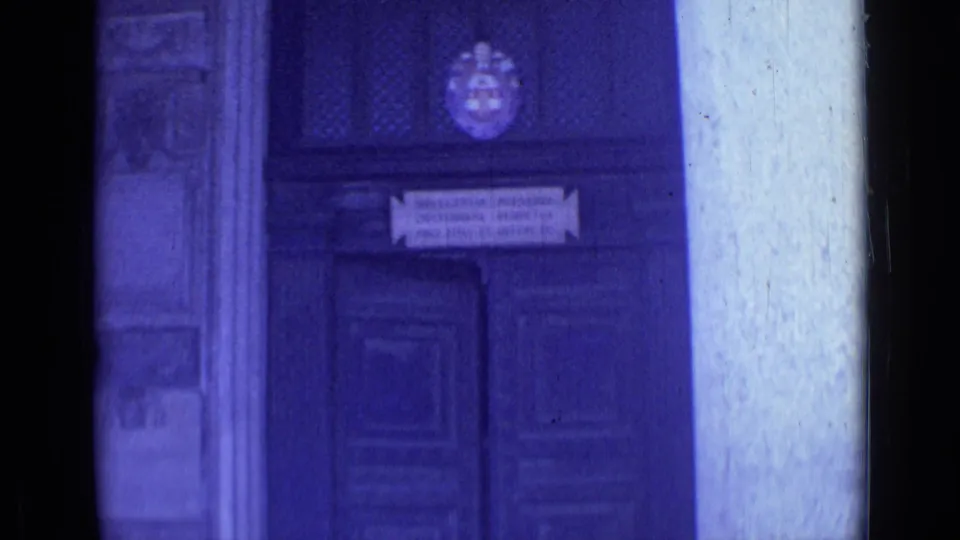 1962 Rome 8mm frame showing a dark wooden religious doorway with a crest, inscription panel, and surrounding stone architectural details.