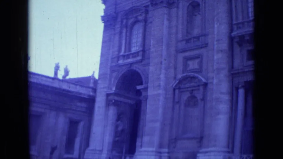 1962 Rome home-movie view tilting toward ornate church architecture, including columns, arches, windows, and statues along the roofline.