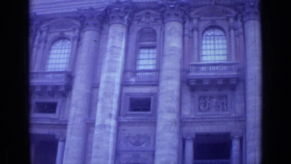 1962 Rome 8mm frame showing columns, gridded arched windows, carved wall panels, and aged purple-blue color shift.