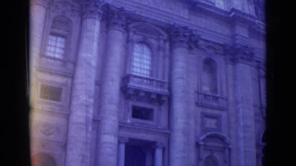 1962 Rome home-movie frame of a grand classical building facade seen from below at a slight angle.
