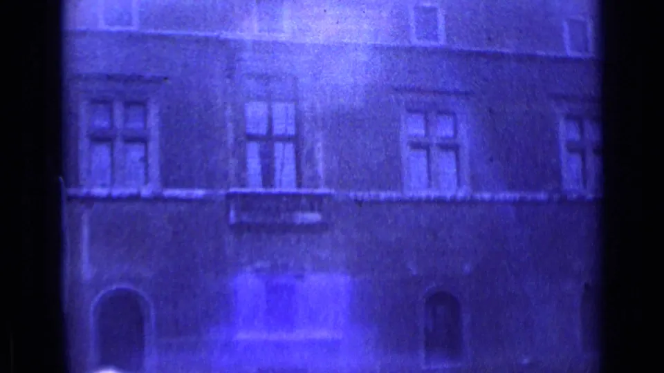 1962 Rome home-movie frame showing a soft blue-purple view of an old masonry facade with windows and arched openings.