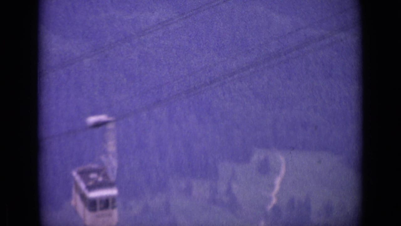1962 Swiss alpine frame showing a small cable car against a misty blue slope, softened by grain and exposure shift.