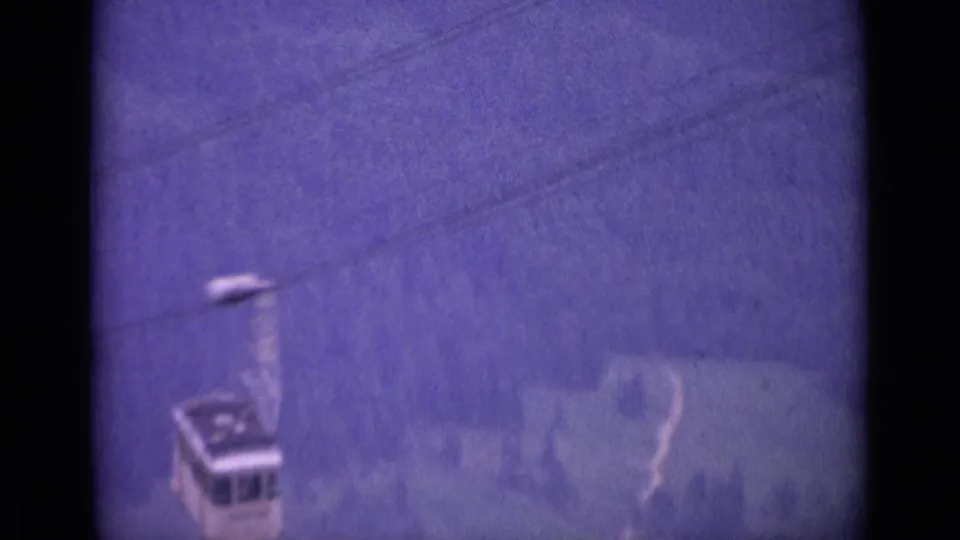 1962 Swiss alpine frame showing a small cable car against a misty blue slope, softened by grain and exposure shift.