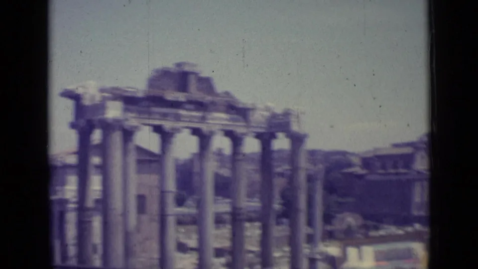 Soft 1962 8mm travel frame showing closer ancient columns and fragmentary arches, likely in a Rome ruins setting.