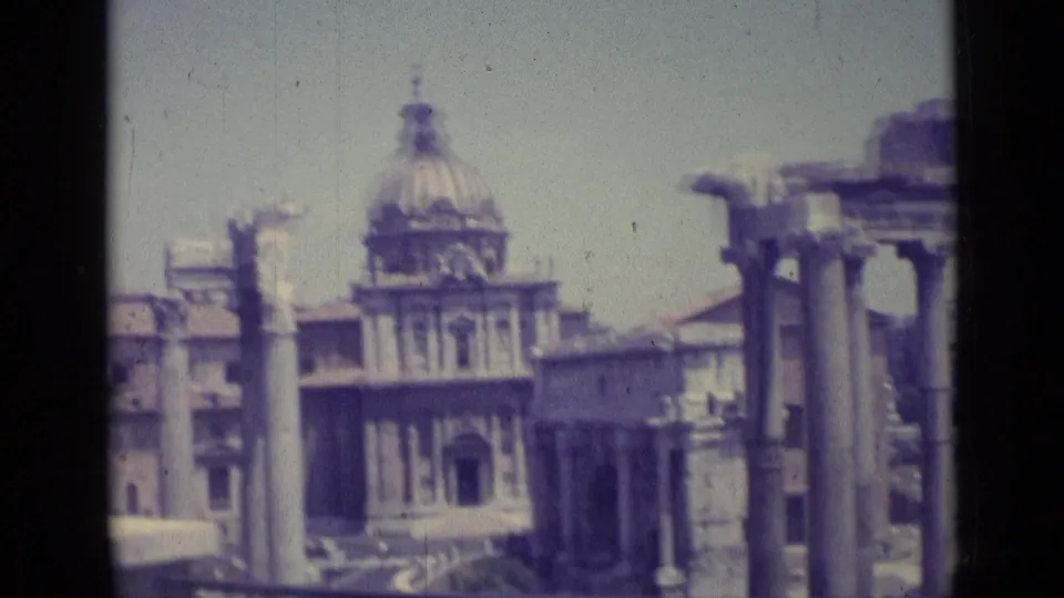 Faded 1962 8mm frame showing a domed church facade beyond columns and ruins in the Vatican City or Rome area.