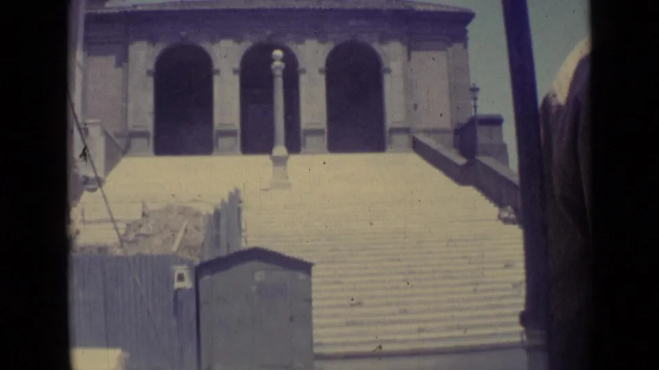 1962 Vatican City travel frame with broad steps, arched openings, street lamps, and partial dark frame borders from the scan.