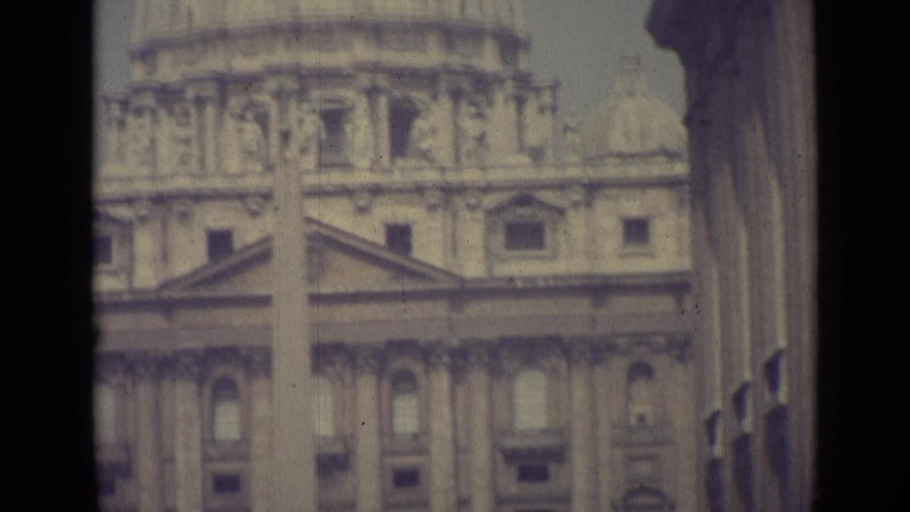 1962 Vatican City home-movie frame showing St. Peter's Basilica facade, classical columns and obelisk in faded 8mm color.