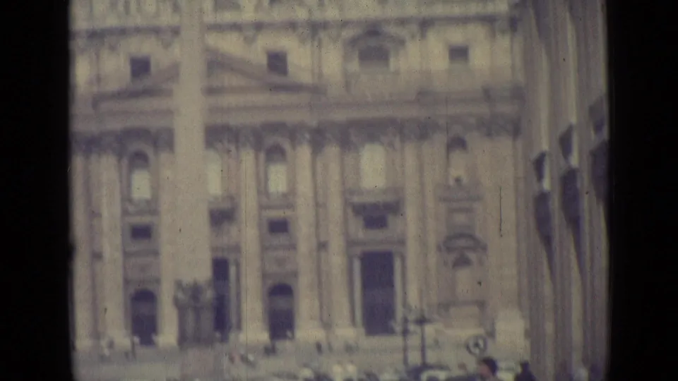 1962 Vatican City frame showing St. Peter's Basilica facade, dome and obelisk through a softly focused 8mm travel-film view.