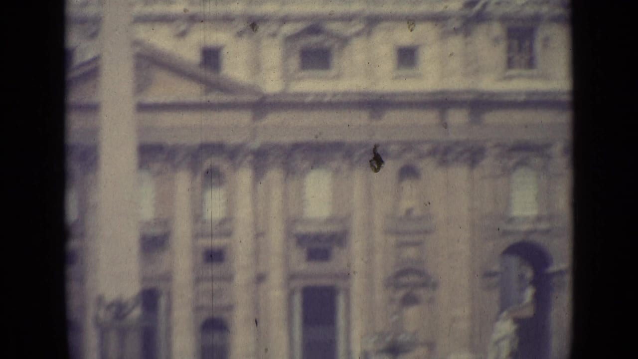 1962 Vatican City 8mm frame showing a blurred monumental facade, columns, windows, and a dark film-frame divider.