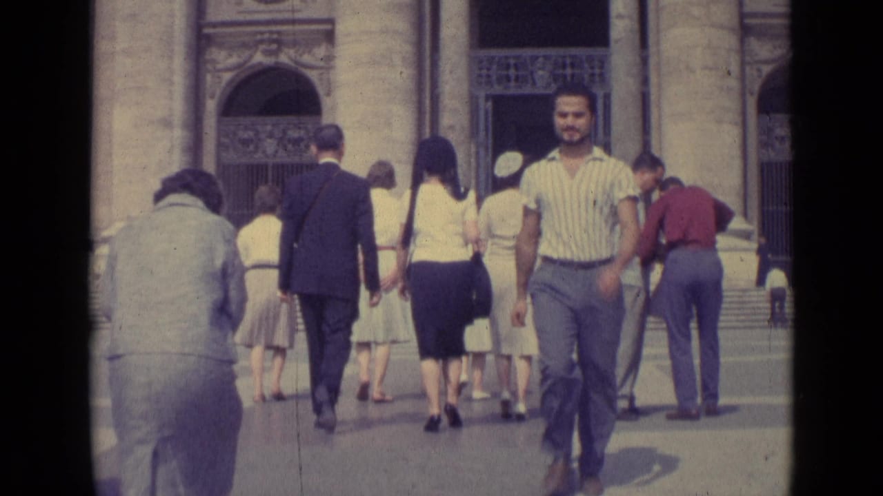 1962 Vatican City frame with pedestrians near a stone entrance and a striped-shirt man looking toward the camera.
