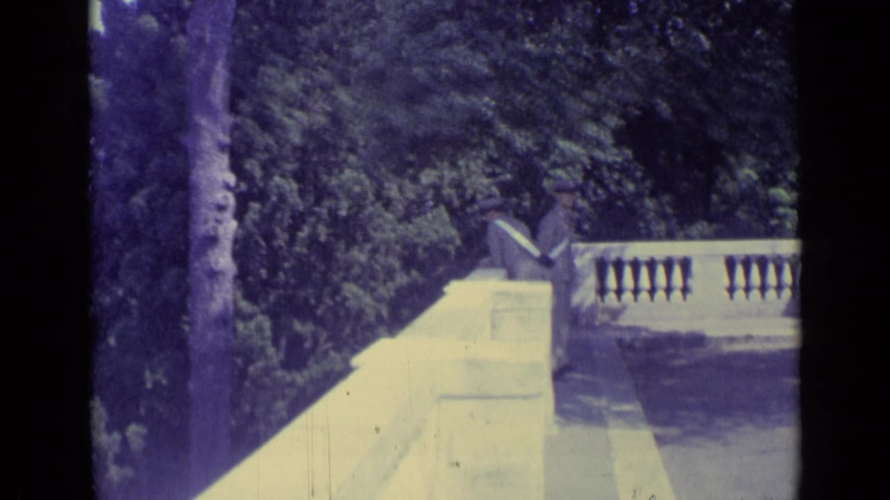 1962 8mm view from a Vatican City terrace, showing trees, stone balustrade, and a distant urban skyline.