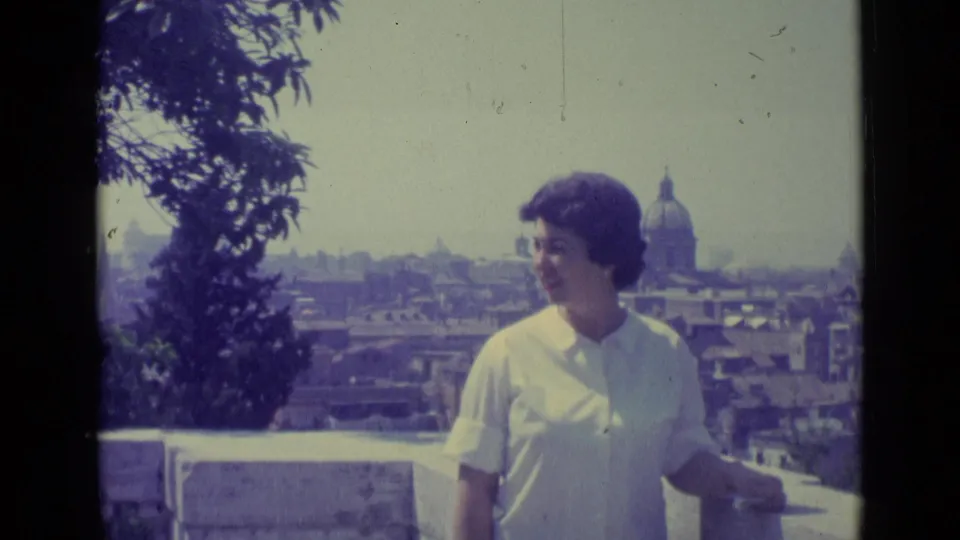 Woman posing on a Vatican City terrace in 1962, with St. Peter's Basilica dome visible in the background.