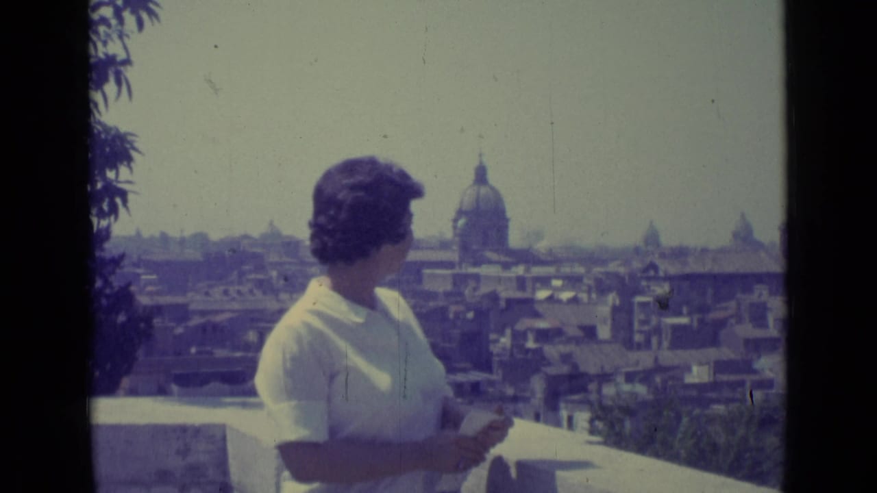 The woman faces the skyline from a balcony, with Vatican City rooftops and a domed landmark visible beyond her.